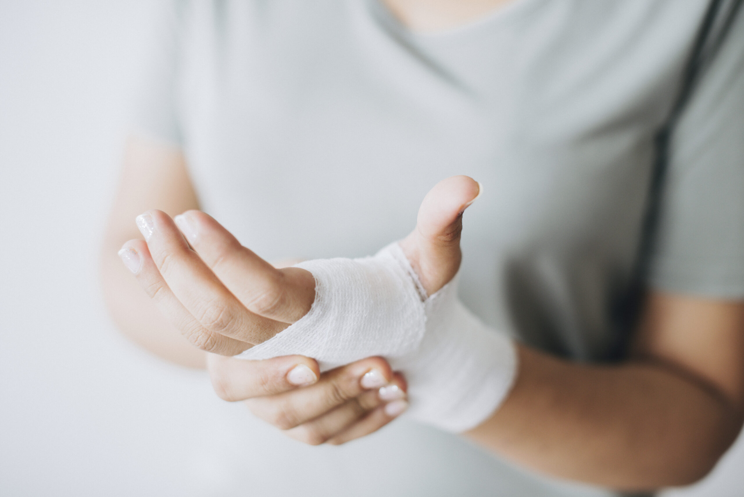 mujer con vendaje de gasa envuelto alrededor de su mano